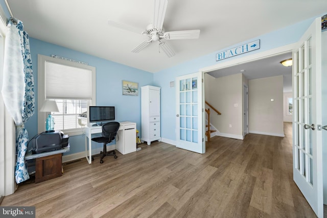 office area featuring french doors, a ceiling fan, baseboards, and wood finished floors