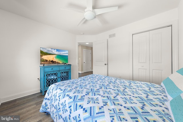 bedroom featuring a ceiling fan, visible vents, dark wood finished floors, baseboards, and a closet