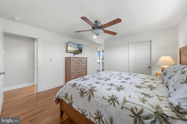 bedroom featuring a ceiling fan, baseboards, and wood finished floors