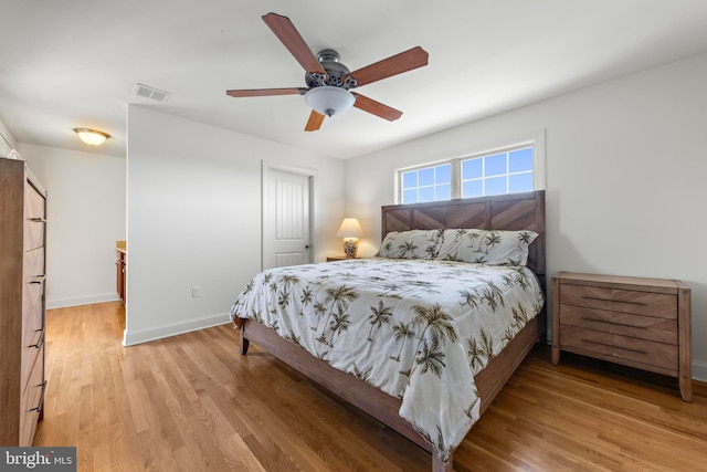 bedroom with visible vents, a closet, baseboards, ceiling fan, and light wood-type flooring