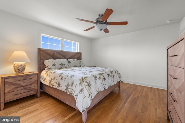 bedroom with baseboards, ceiling fan, and wood finished floors