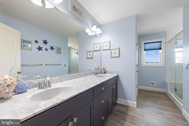 bathroom featuring visible vents, a sink, and wood finished floors