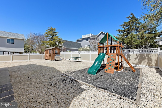 view of play area featuring an outdoor structure, a fenced backyard, and a storage shed