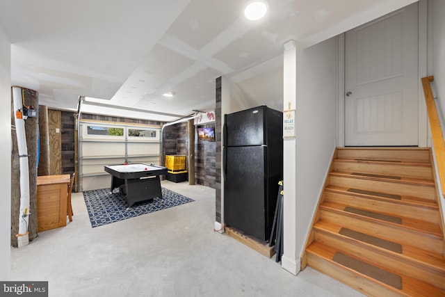 interior space featuring freestanding refrigerator and concrete floors