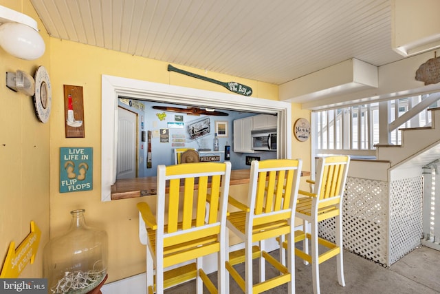 dining area featuring concrete flooring and stairs