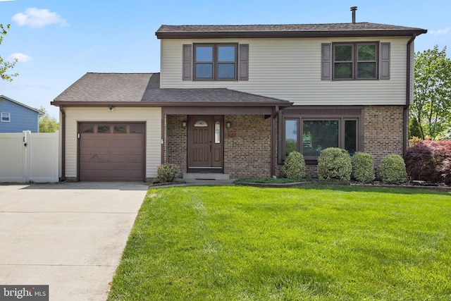 traditional home with a garage, fence, a front lawn, concrete driveway, and brick siding