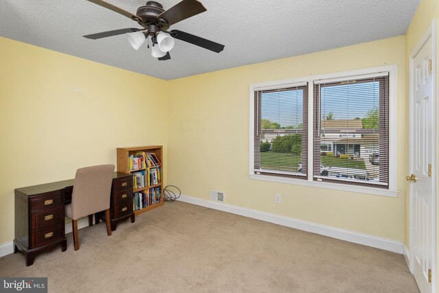 carpeted office with baseboards, ceiling fan, visible vents, and a textured ceiling