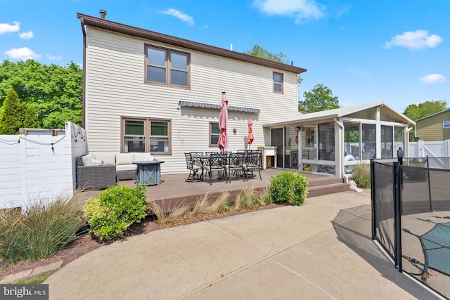 back of house with outdoor dining space, outdoor lounge area, fence, a patio area, and a sunroom
