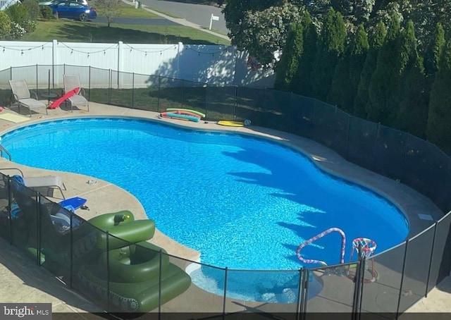 view of swimming pool featuring a patio area, fence, and a fenced in pool