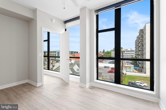1320 Fenwick Ln Unit 402, Silver Spring, MD 20910 - spare room with baseboards, a city view, and wood finished floors