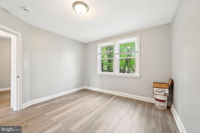 spare room featuring baseboards and light wood-style flooring