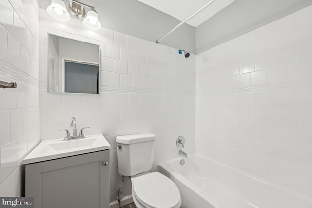 full bath featuring toilet, shower / washtub combination, tile walls, and vanity