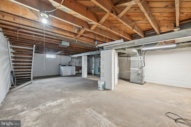 below grade area featuring heating unit and independent washer and dryer