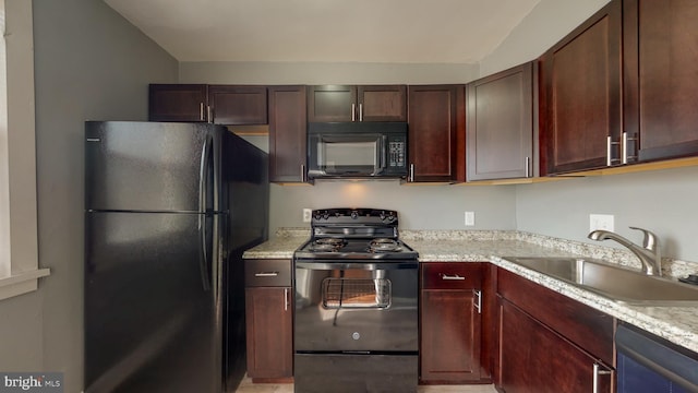 kitchen with a sink, vaulted ceiling, and black appliances