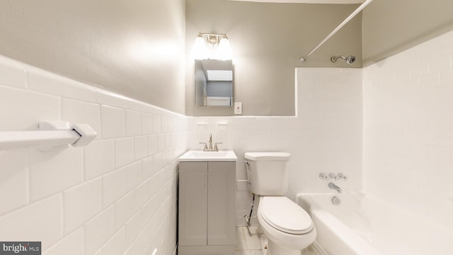 bathroom featuring vanity, tub / shower combination, toilet, and tile walls