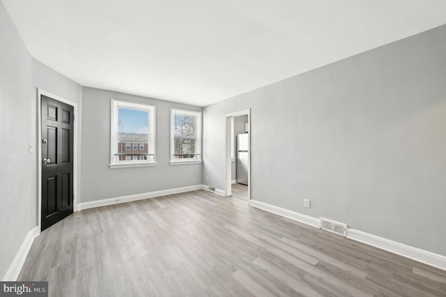 interior space featuring baseboards, wood finished floors, and visible vents