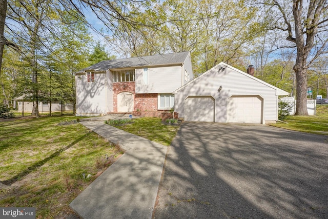 view of front facade featuring brick siding, an attached garage, driveway, and a front lawn