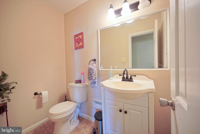 half bathroom with toilet, baseboards, tile patterned floors, and vanity
