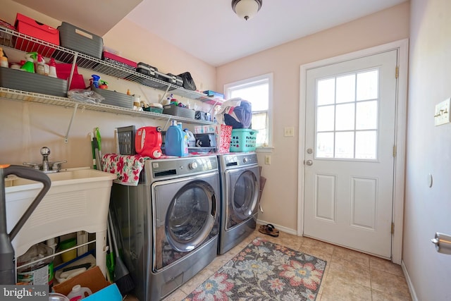 laundry room with washing machine and clothes dryer, light tile patterned flooring, laundry area, and baseboards
