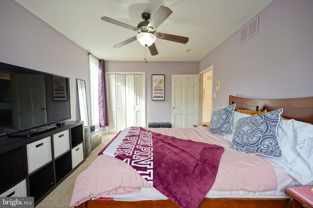 carpeted bedroom with ceiling fan, a closet, and visible vents