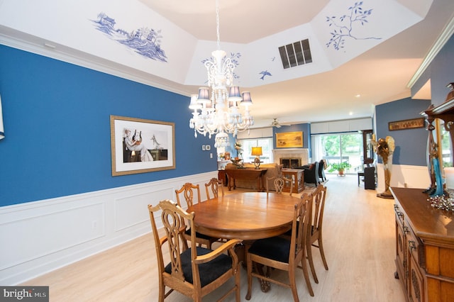 2210 Horns Point Rd, Cambridge, MD 21613 - dining room with light wood-style floors, a chandelier, a wainscoted wall, a fireplace, and ornamental molding