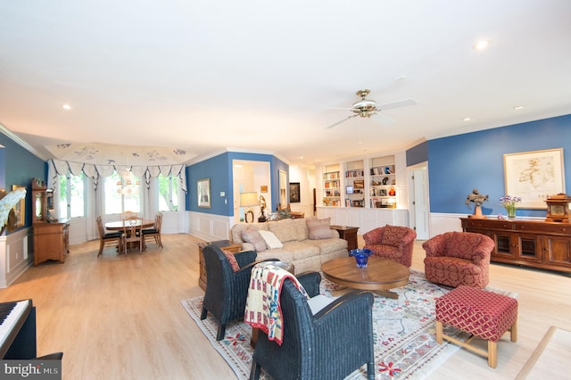 2210 Horns Point Rd, Cambridge, MD 21613 - living room featuring ornamental molding, built in shelves, wainscoting, light wood-style floors, and ceiling fan