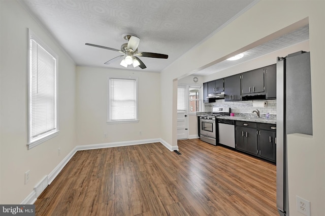 6824 Duluth Ave, Dundalk, MD 21222 - kitchen featuring appliances with stainless steel finishes, wood finished floors, light countertops, under cabinet range hood, and a ceiling fan