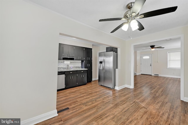 6824 Duluth Ave, Dundalk, MD 21222 - kitchen with appliances with stainless steel finishes, ceiling fan, tasteful backsplash, light wood-style floors, and baseboards