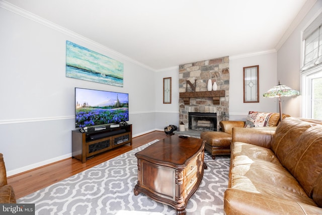 living area featuring baseboards, ornamental molding, a fireplace, and wood finished floors