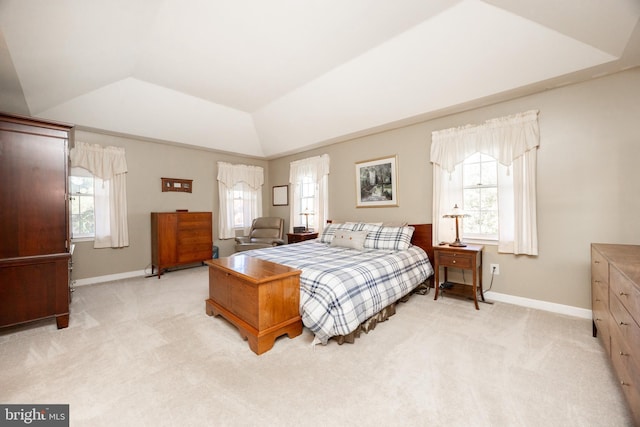bedroom featuring baseboards, lofted ceiling, and light colored carpet