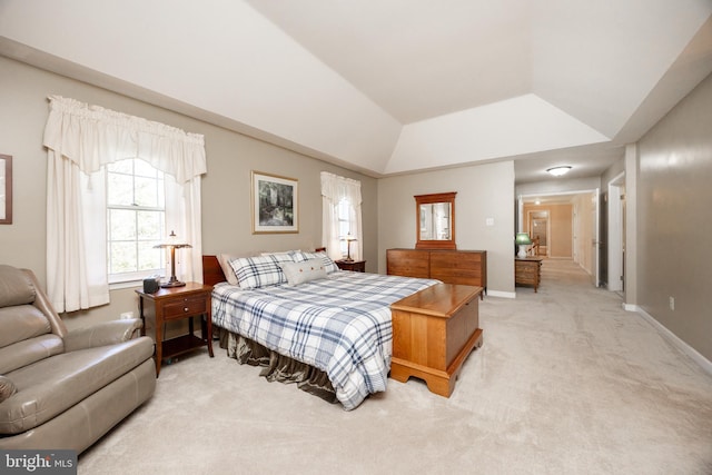 bedroom featuring light colored carpet, baseboards, and lofted ceiling