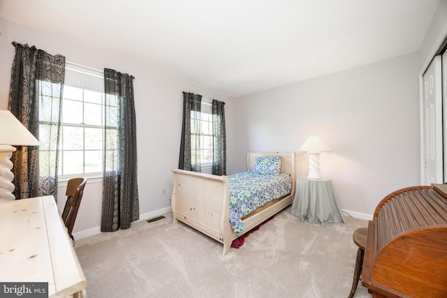 bedroom with baseboards, carpet, a closet, and visible vents