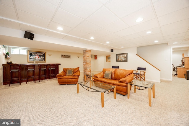 living area featuring carpet floors, baseboards, a drop ceiling, recessed lighting, and a dry bar