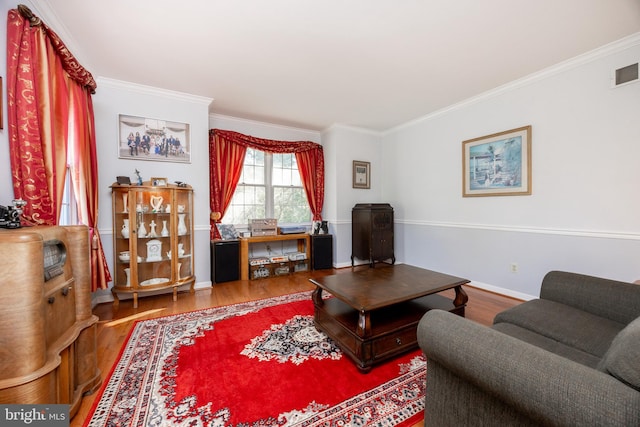 living area featuring crown molding, wood finished floors, and visible vents