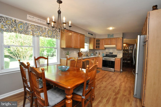 dining area featuring visible vents, baseboards, a notable chandelier, and light wood finished floors
