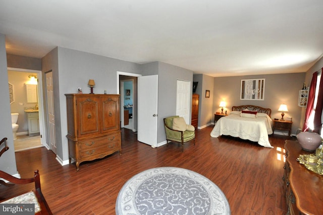 bedroom with baseboards, a closet, wood finished floors, and connected bathroom