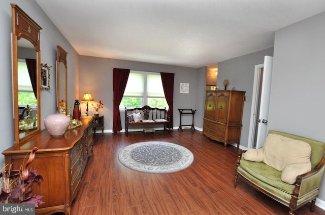 sitting room with baseboards and dark wood finished floors