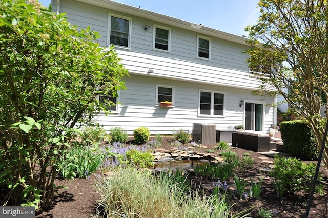 back of house featuring central air condition unit and an outdoor living space