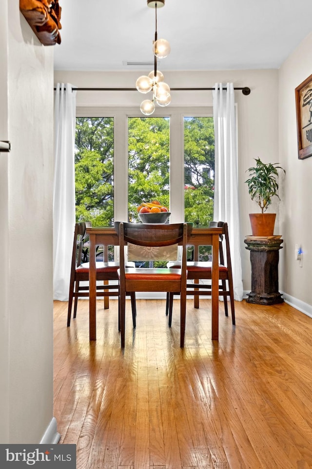 1 Christian St Unit 44L, Philadelphia, PA 19147 - dining area featuring a healthy amount of sunlight, baseboards, hardwood / wood-style floors, and a notable chandelier
