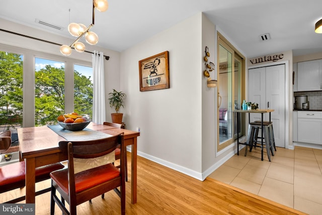 1 Christian St Unit 44L, Philadelphia, PA 19147 - dining room featuring a chandelier, baseboards, visible vents, and light wood-type flooring