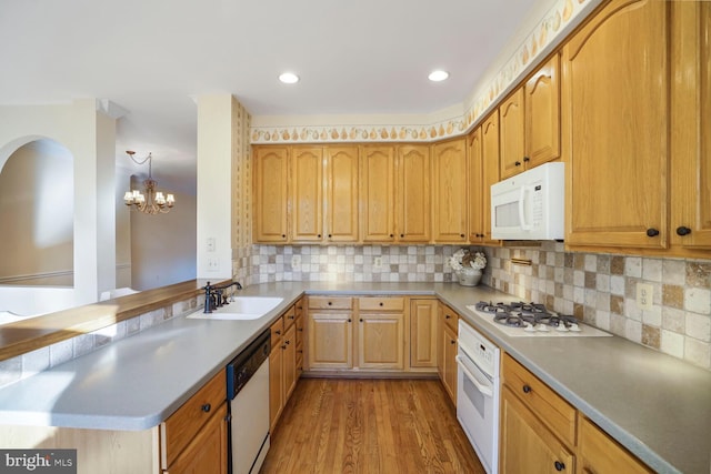 3016 Fallswood Glen Ct, Falls Church, VA 22044 - kitchen with backsplash, light wood-type flooring, a sink, a notable chandelier, and white appliances