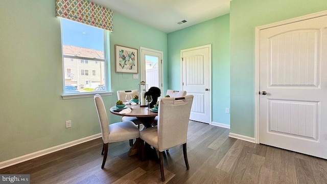 dining space featuring baseboards, wood finished floors, and visible vents
