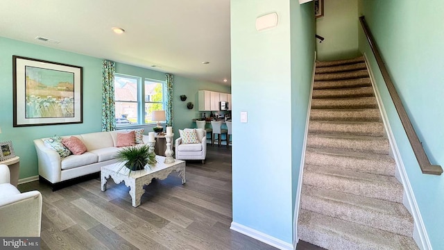 living area with visible vents, dark wood finished floors, recessed lighting, and stairway