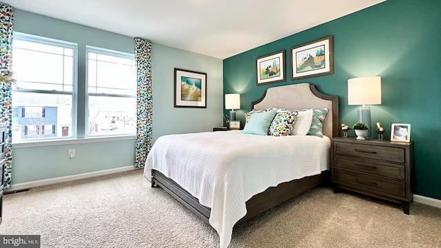 bedroom featuring carpet floors, baseboards, and multiple windows