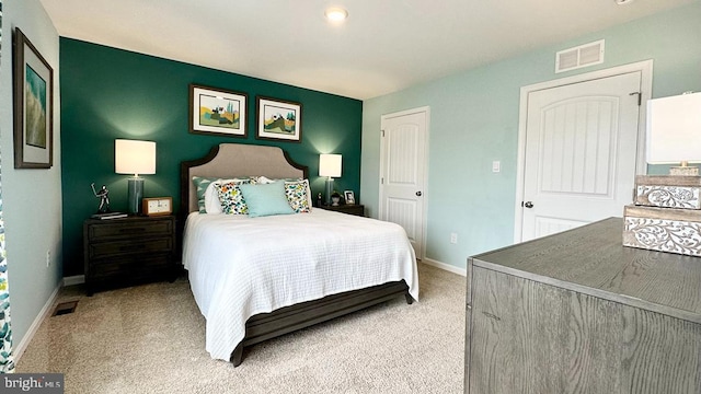 bedroom with baseboards, light carpet, and visible vents