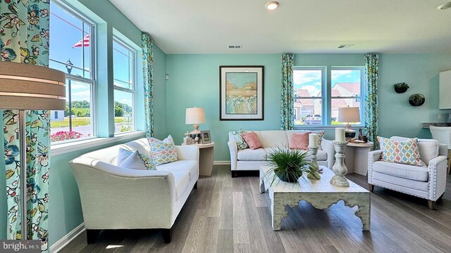 living area with baseboards, recessed lighting, wood finished floors, and visible vents