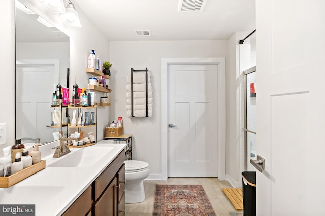 bathroom with baseboards, vanity, and visible vents