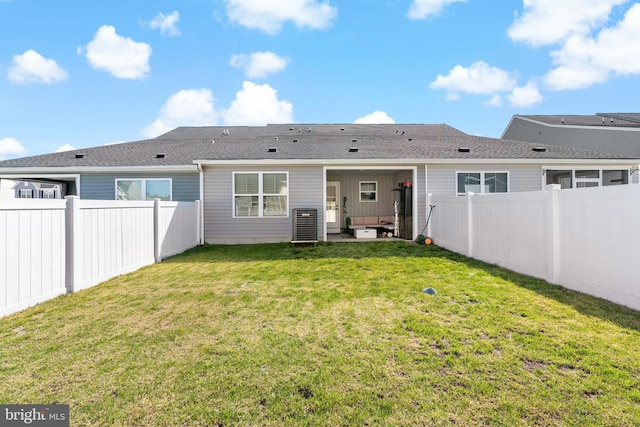 rear view of property with a yard, a fenced backyard, and roof with shingles