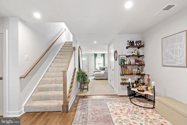 interior space featuring visible vents, baseboards, stairway, recessed lighting, and light wood-type flooring