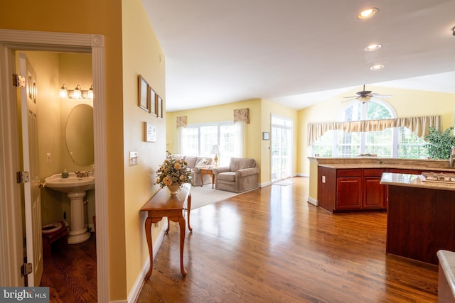 kitchen featuring ceiling fan, wood finished floors, baseboards, reddish brown cabinets, and recessed lighting